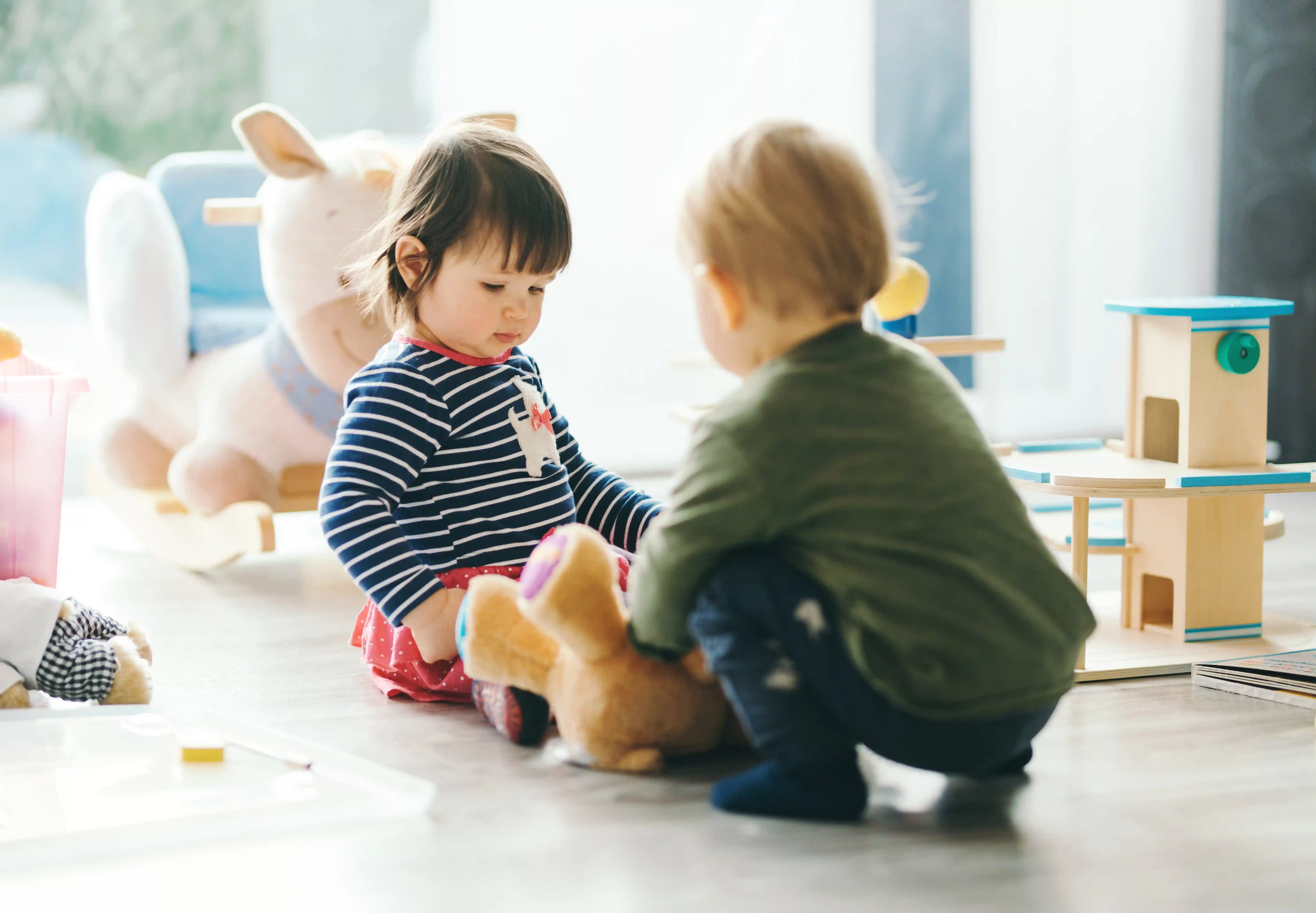 gro-up twee peuters spelen samen met een knuffel