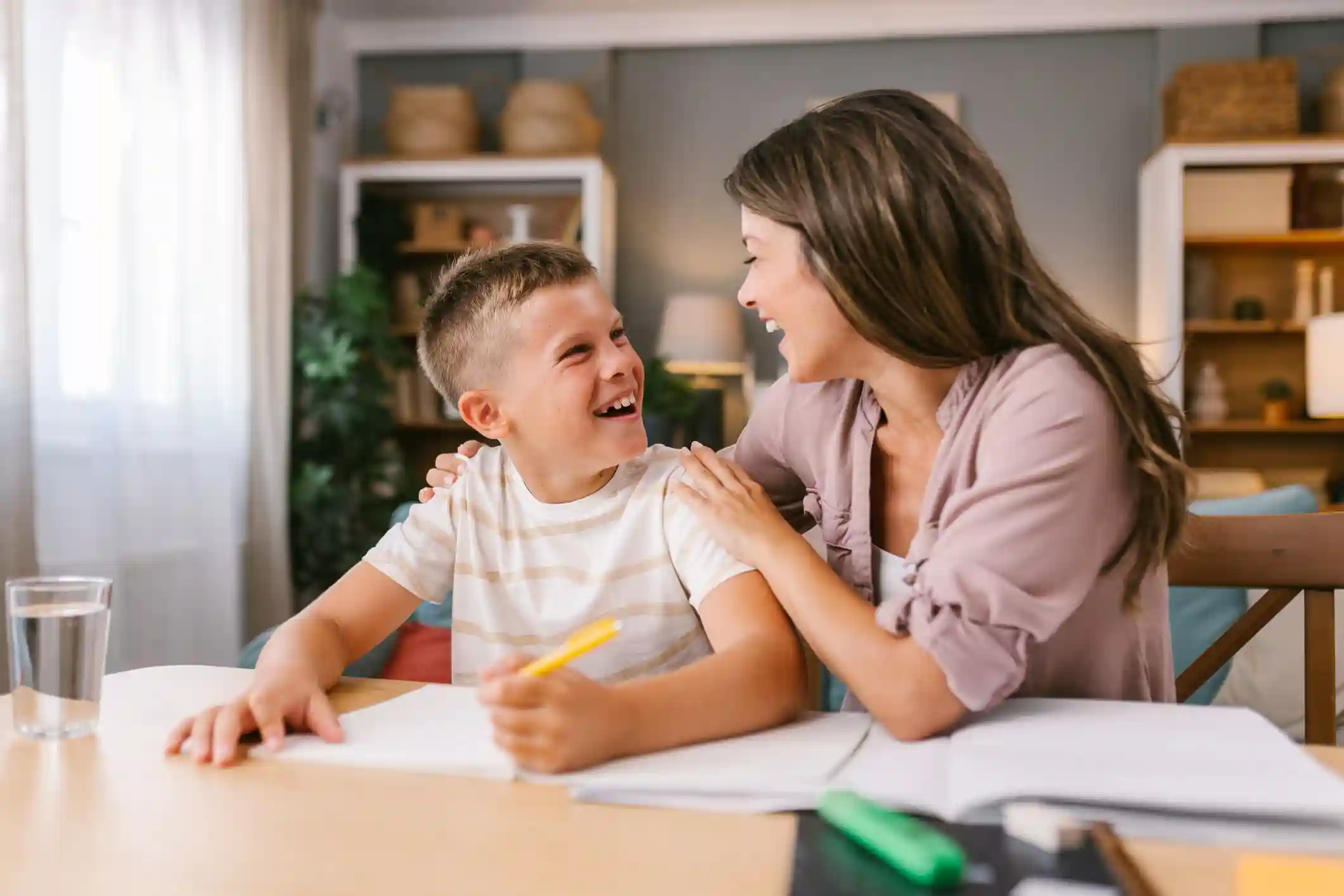 gro-up kind maakt huiswerk en ouder geeft een compliment