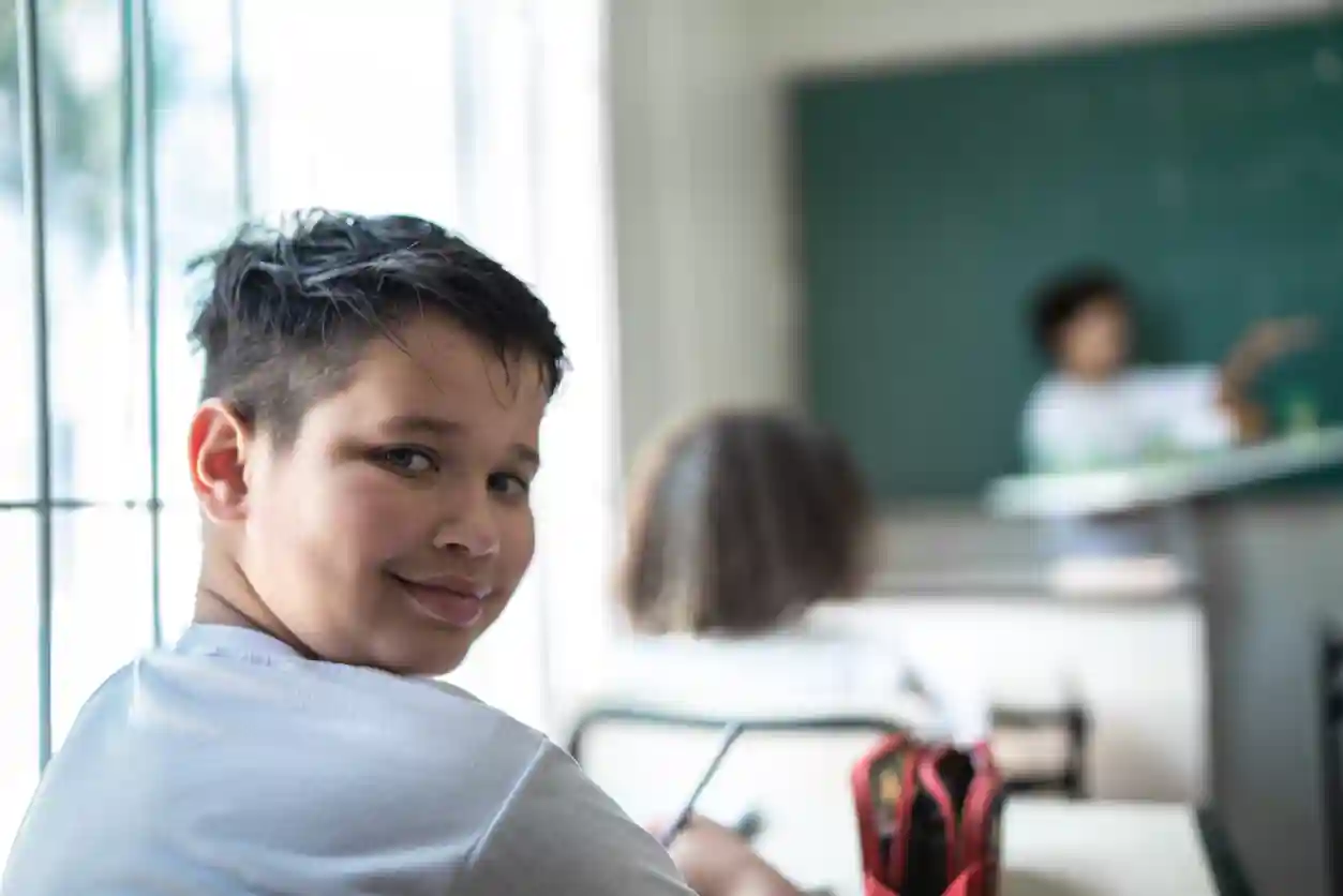 gro-up kinderen jongetje kijkt om in de klas